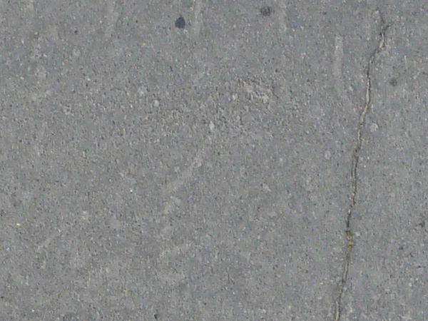 Asphalt texture with cracks and scratches of various sizes, depths and hues of grey.